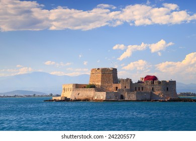 Blue sea surrounds the fortress of Bourtzi guarding the entrance to Nafplio harbor, Greece - Shutterstock ID 242205577