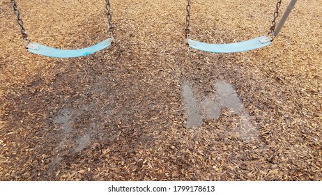 Blue Seat On Swing With Water Puddle And Mulch