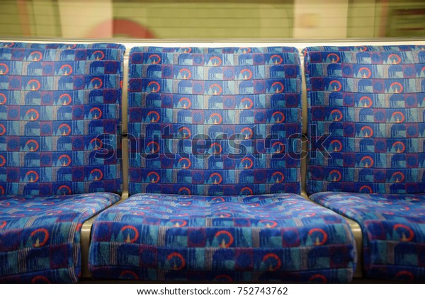 Blue seats on the\
Central line, London, UK.