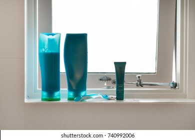 Blue Shampoo And Conditioner Bottles On Bathroom Window Ledge