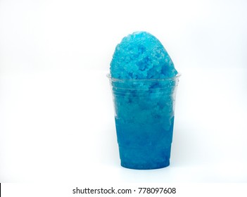 Blue Shaved Ice, Shave Ice Or Snow Cone In A Clear Cup With A White Background.