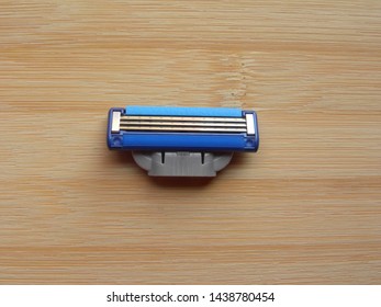 Blue Shaving Razor Blade Cartridge Kept On Wooden Table