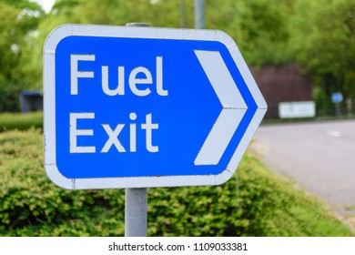 A Blue Sign Directs Traffic Towards The Fuel And Exit Of A Motorway Service Station In The UK.