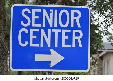 A Blue Sign Instructs Senior Center With An Arrow Pointing Right.