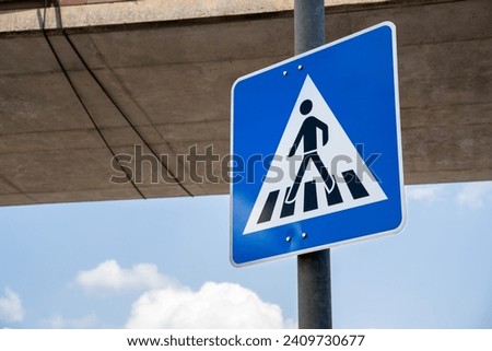Blue sign with a pedestrian on the crosswalk