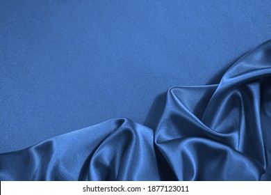      Blue silk satin fabric background. Copy space for your design. Delicate wavy folds. Beautiful elegant blue background.                          