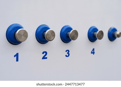 Blue and silver knobs are mounted on a clean white wall, creating a modern and stylish look.
