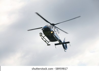 Blue And Silver Police Helicopter Flying Above