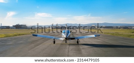 Blue single propeller plane prepared before takeoff on the empty runway of Sabadell airport on a sunny summer day