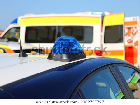 blue sirens of the police car and the ambulance in the background after the serious road accident with injuries