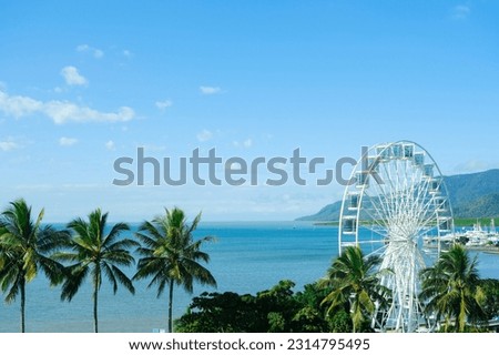  Blue skies and the clear turquoise waters of the Coral Sea framed by palm trees at Cairns Esplanade — Far North Queensland, Australia