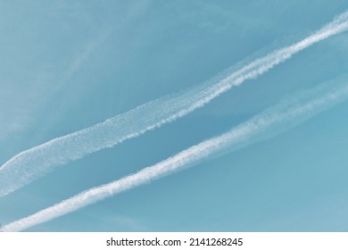 Blue sky with airplane contrails as abstract background.