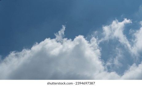 Blue sky background, adorned with wisps of white clouds, creates a serene and picturesque atmosphere.