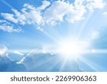 Blue sky background with clouds and sun rays coming out. 