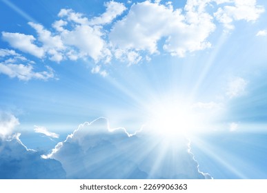 Blue sky background with clouds and sun rays coming out. 