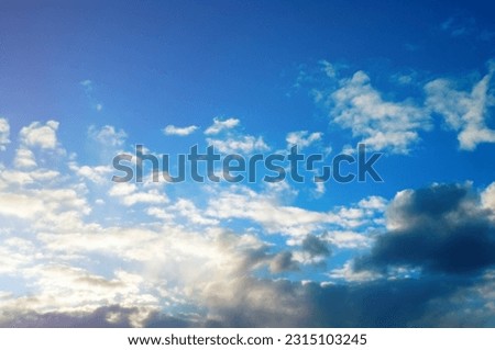 Blue sky background, picturesque cumulus clouds in the evening blue sky, vast sky landscape
