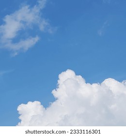 In the blue sky, a close-up of a combination of white and light gray clouds is visible. These clouds create a mesmerizing spectacle against azure background, their fluffy captivate the eye of  viewer.