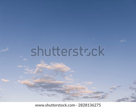 A blue sky with a cloud, just before nightfall