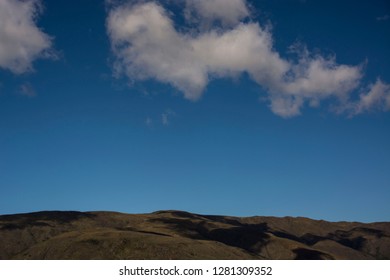 Blue sky with cloud over high mountain horizon