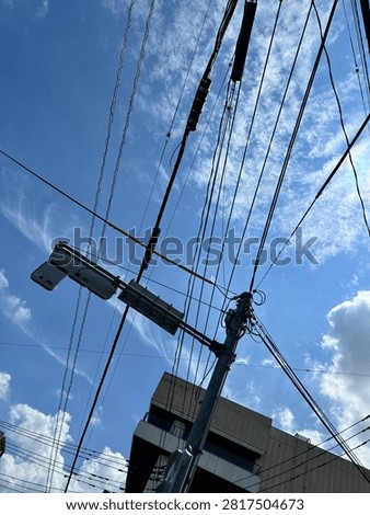 Blue sky, clouds and entangled cables.