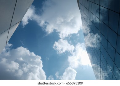 Blue sky with a lot of clouds reflected modern building mirror.