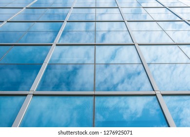 Blue sky and clouds reflected in structural  modular glass wall 