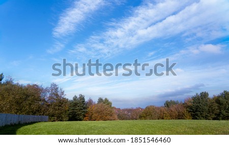 Blue sky and cloudscape with green fields in the sunny day for Autumn, Lanscape of grass field with forest trees and enviroment public park , Beutiful Horizontal of natural background