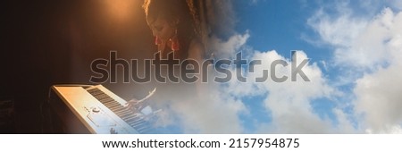 Blue sky with copy space against mid section of african american female artist playing piano. music festival and concert concept