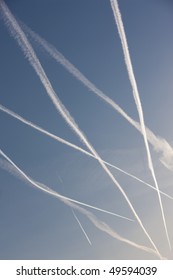 A blue sky crossed by vapour trails from several planes.