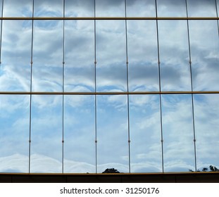 blue sky and curly clouds reflection on a glass facade