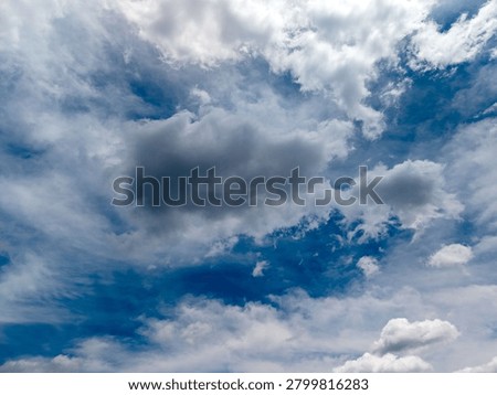 Blue sky developing various cloud types, including fluffy white cumulus clouds and darker grey formations, creating a dynamic weather background over union county, new jersey