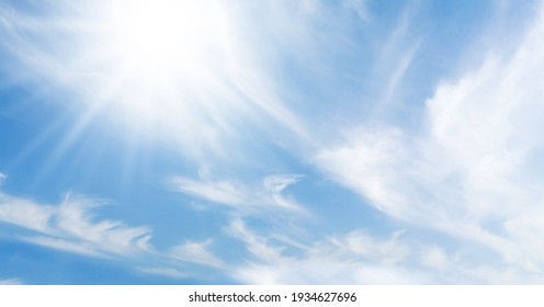 Blue sky with light clouds and bright sun. Summer sky backdrop