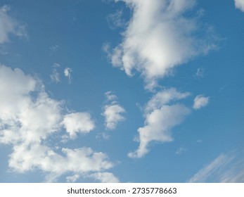Blue sky minimal clouds create a clean, uplifting background with plenty of open space for text and design elements. Soft cumulus formations float across a light-blue gradient, conveying calm weather, optimism, and a fresh start. The horizonless composition keeps distractions out of frame, making this image highly versatile as a neutral nature backdrop for websites, social media banners, flyers, presentations, or inspirational quote graphics. Brands in wellness, travel, aviation, sustainability, and faith-based communication can all use this airy skyscape to express freedom, positivity, and clarity.