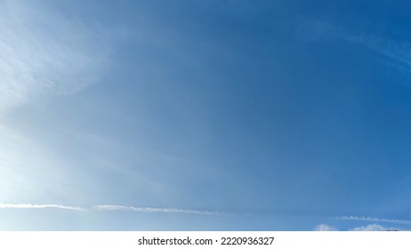 Blue sky with occasional clouds. Autumn day high in the sky translucent white cirrus and cumulus clouds. They are blurry translucent and have different shapes and sizes. - Shutterstock ID 2220936327