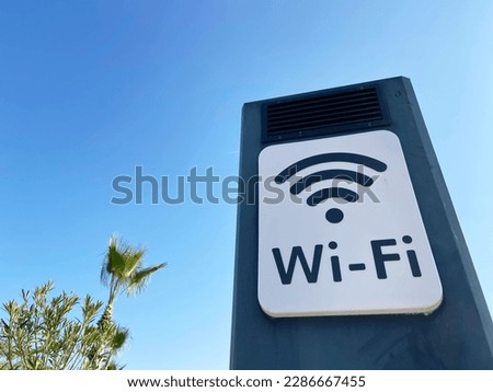 Blue sky, palms, beach and board saying FREE WIFI, closeup