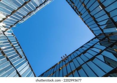 The Blue Sky Is Reflected In The Windows Of The Modern Glass Facade. Architectural Abstraction. Modern Space.Travel Destination Concept. Copy Space.