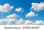 Blue sky with scattered white cumulus clouds. 
