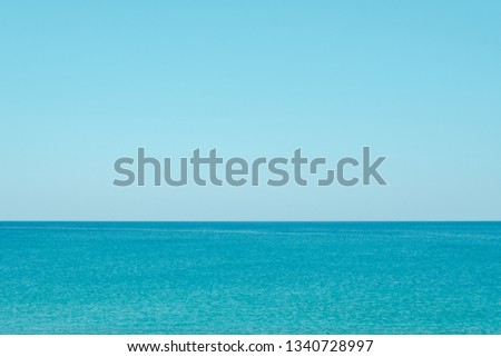 Similar – two straw beach umbrellas on an empty seashore on a clear day