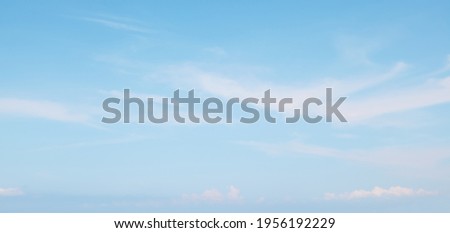 Blue sky in soft white clouds. Beautiful Panoramic Natural cloudscape background, texture for Design. Sky over sea horizon. Wide Angle Delicate Wallpaper or Web banner With Copy Space.