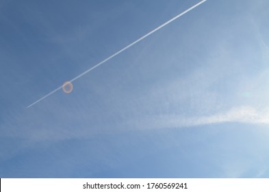 In The Blue Sky The Track From The Plane Is White. Bright Sun, Glare. Travels.