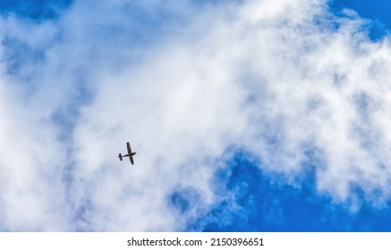 In A Blue Sky With A White Cloud Flying A Single Engine Airplane