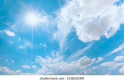 Blue sky and white clouds background - Pillowy clouds cover a blue sky in the background