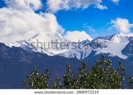 Blue sky with white clouds over snow peaks of Himalayan mountains, beautiful scenic image of Leh, Ladakh, India. Ladakh is world famous for its natural beauty of Himalayan mountain scape.