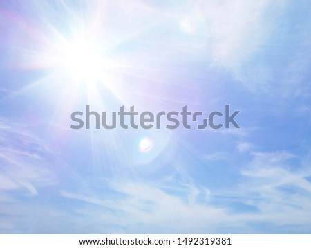 Blue sky with white fluffy clouds and sun reflection. Sunny background. Sun appear directly above Thailand. The afternoon summer sun shines on a beautiful sky with clouds.