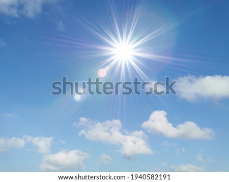 Blue sky with white fluffy clouds and sun reflection. Sunny background. Sun appear directly above Thailand. The afternoon summer sun shines on a beautiful sky with clouds. Hot weather, summer season.
