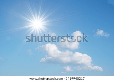 Blue sky with white fluffy clouds and sun reflection. Sunny background. Sun appear directly above Thailand. The afternoon summer sun shines on a beautiful sky with clouds. Hot weather, summer season.
