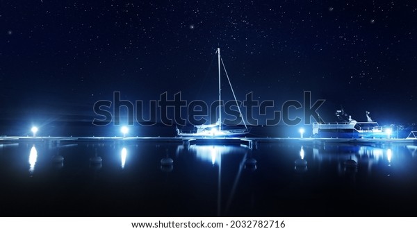 Blue sloop rigged yacht moored to a pier in\
marina at night. Clear twilight sky, stars, starlight, moonlight,\
lots of lights. Concept landscape. Copy space, graphic resources.\
Stockholm archipelago