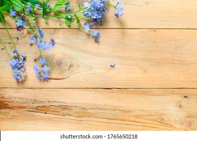 Blue Small Forget-me-nots Flowers On A Wooden Background. The Concept Of Eco Style, Natural Texture. Space For Text. Flatlay