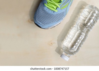 Blue Sneakers And 1 Bottle Of Water. Beverage.Placed On A Light Brown Wood Floor. Concept: Sports ,Fitness , Running ,Health  And Exercise. Zumba Dance Workout For Weight Loss.