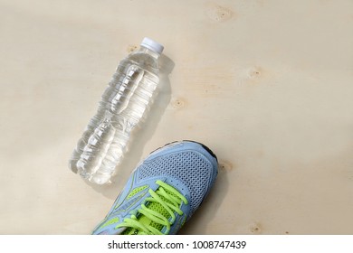 Blue Sneakers And 1 Bottle Of Water. Placed On A Light Brown Wood Floor. Concept: Sports ,Fitness , Running ,Health  And Exercise. Zumba Dance Workout For Weight Loss.